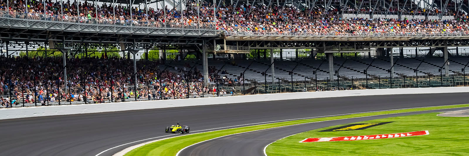 Stock photo from Indianapolis Motor Speedway with fans in the stands and one racecar, purchased from Big Stock